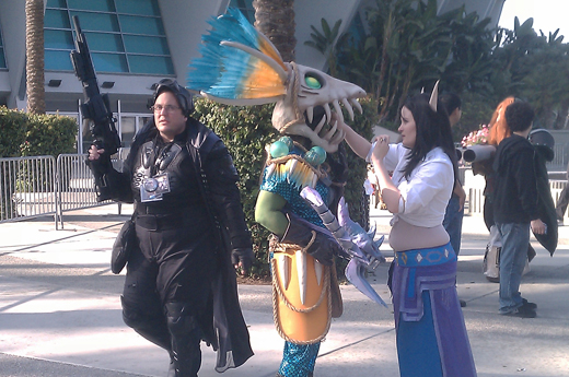 Cosplayers from Blizzcon. A blood elf is helping a hunter with her helm.